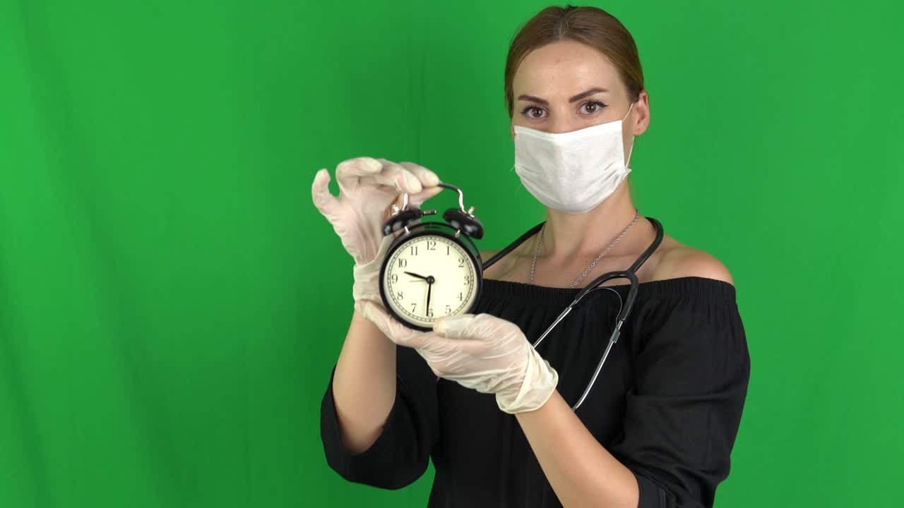 concept de estilo de vida saludable de la mujer médica - sosteniendo el despertador negro en la pantalla verde