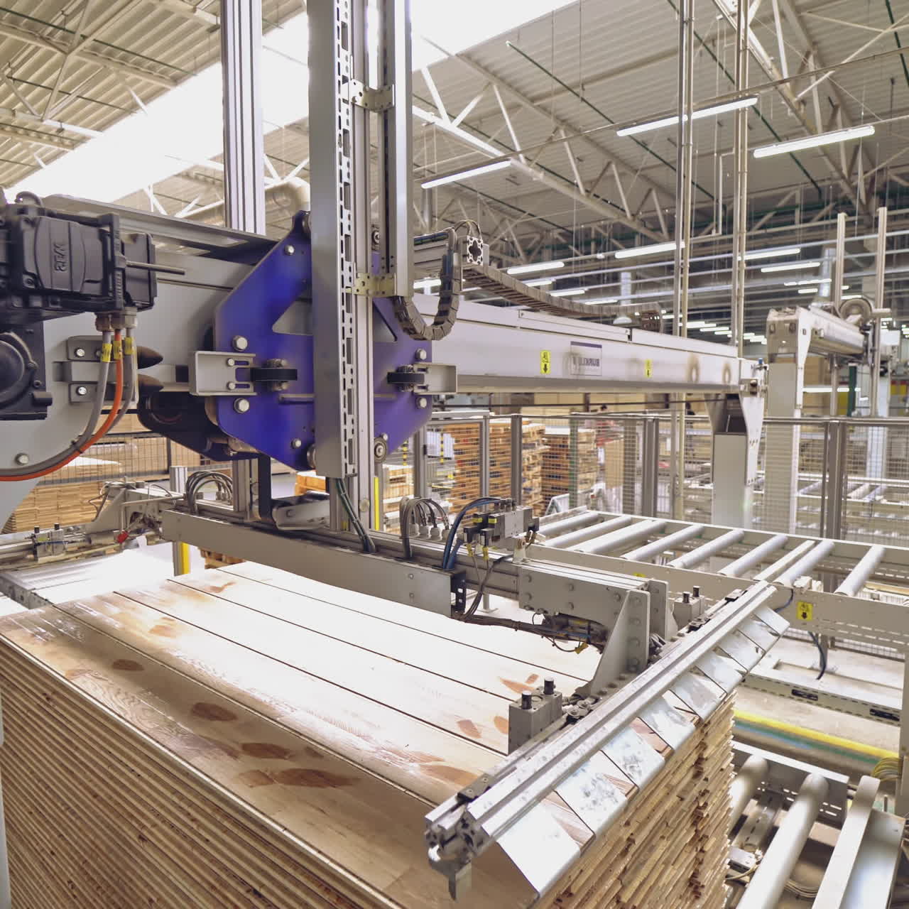 Polished wooden parquet passes the final stage of processing and a special device puts it on the stockpile. Parquet plant.