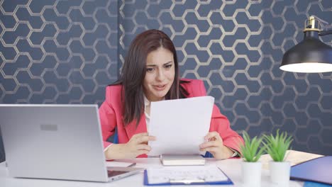 la joven mujer de negocios mira el documento en su mano y se alegra.