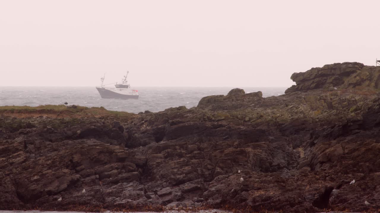 boat trawler passing behind St Clement's Isle, Cornwall