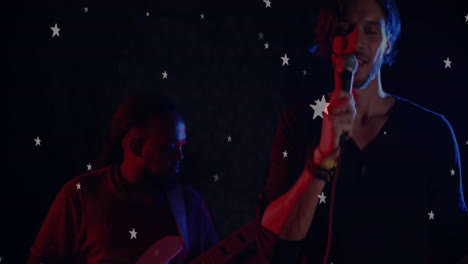 singer gripping microphone and guitarist playing on music stage, featuring floating star graphics