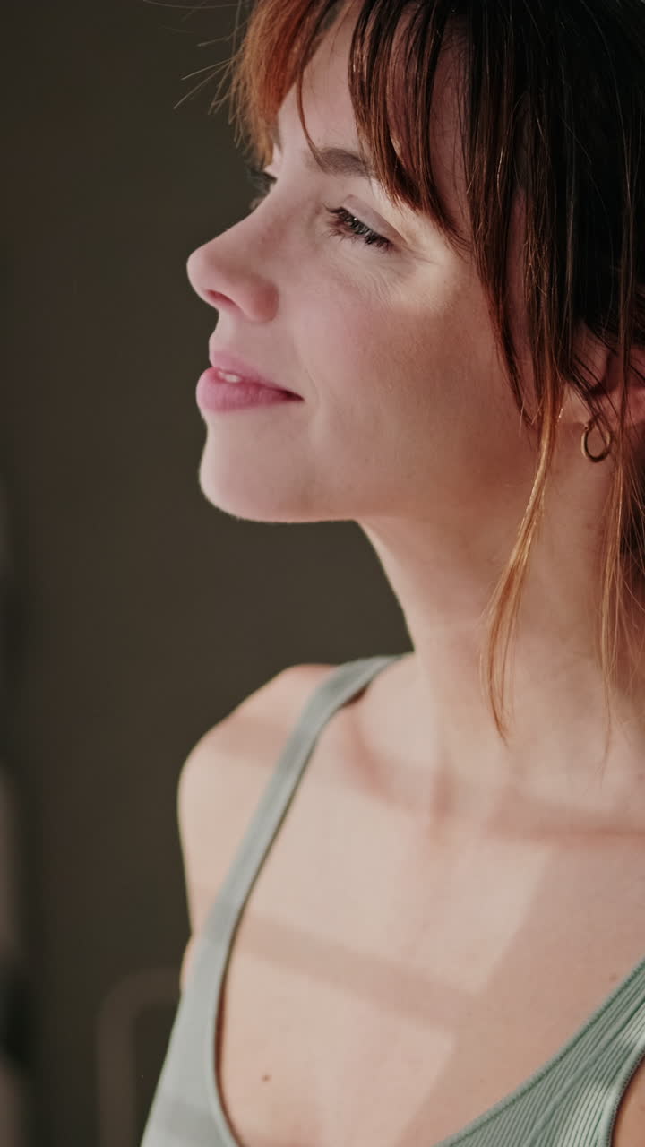Primo piano del profilo di una giovane donna serena con luce naturale