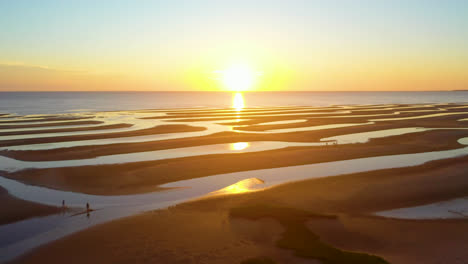 cape cod bay beach aerial drone footage sun set at low tide during golden hour with people walking