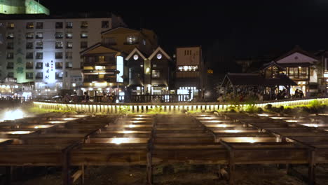 Der-Berühmte-Yubatake-Im-Dorf-Kusatsu-Onsen-In-Gunma,-Japan-Während-Des-Aufleuchtens-An-Einem-Kühlen-Sommerabend-Mit-Aufsteigendem-Heißem-Dampf