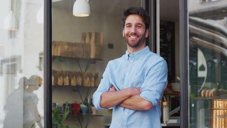 retrato del propietario masculino de pie fuera de la cafetería