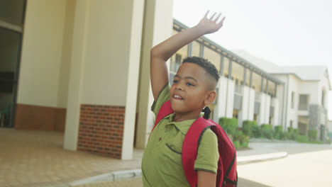 Video-Eines-Glücklichen-Afroamerikanischen-Jungen,-Der-Seinen-Kollegen-Vor-Der-Schule-Zuwinkt