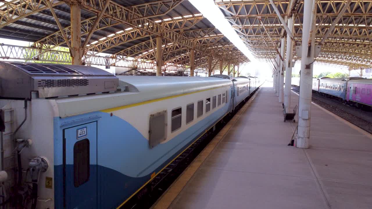 Passenger train parking at a station platform, under a large steel roof, at Mar del Plata station, Buenos Aires.