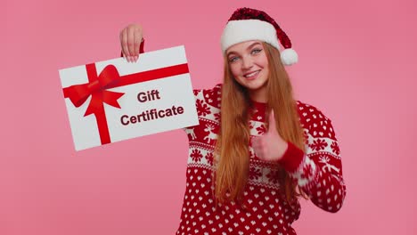 Adult-girl-wears-red-New-Year-sweater-and-hat-presenting-card-gift-certificate-coupon-winner-voucher