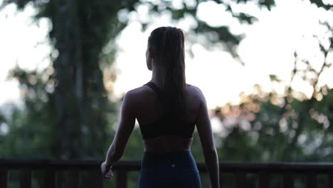 mujer modelo en traje de yoga afuera en la cubierta puesta de sol en la jungla