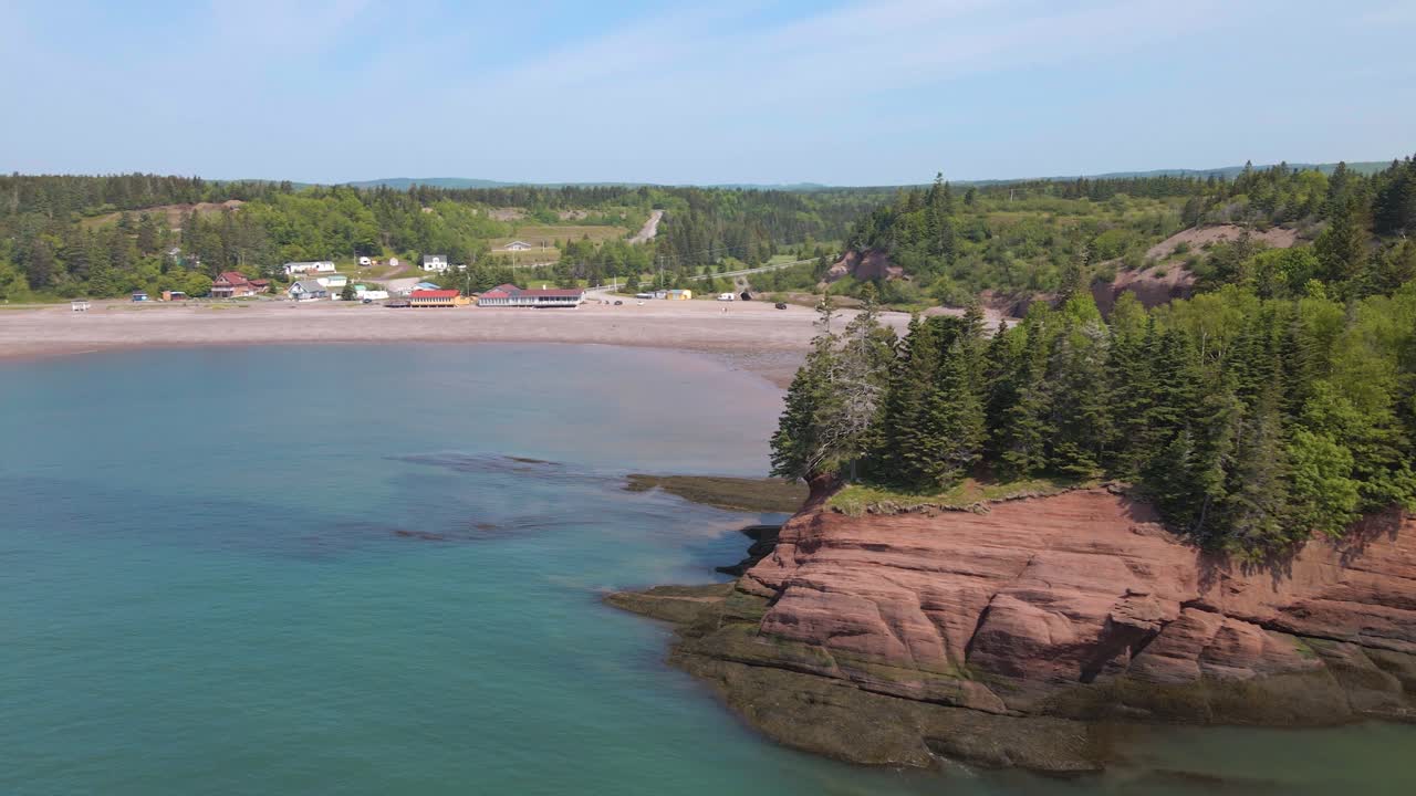 Drone shot on a beautiful sunny day of the popular St Martins Cave located on the Bay of Fundy, revealing the beach in the Province of New Brunswick in Canada shot in 4k during a hot summer day