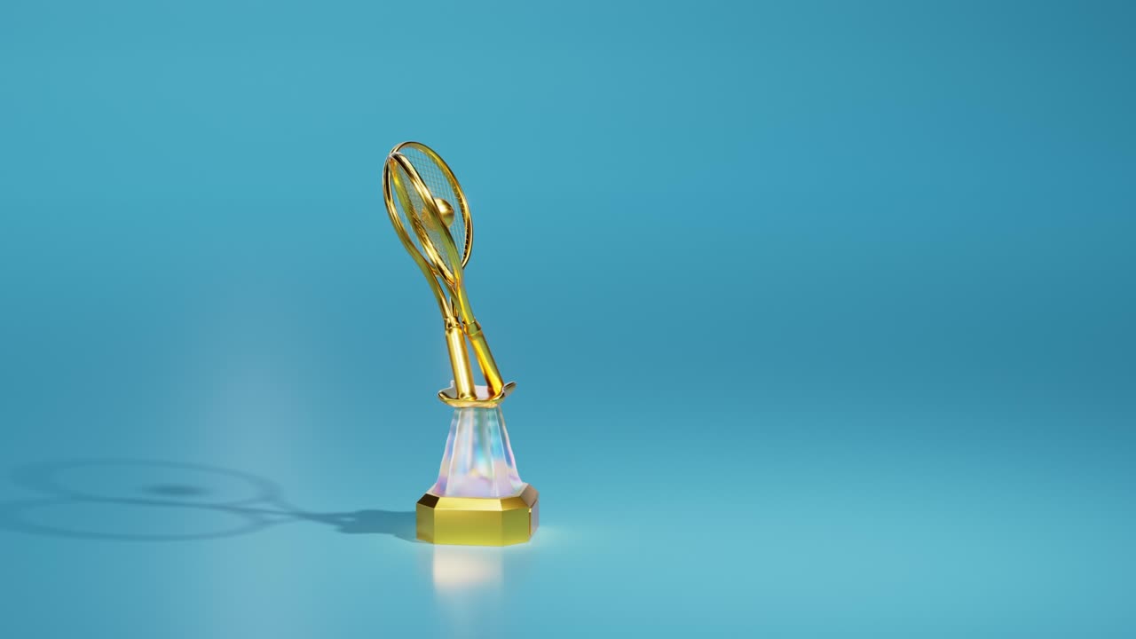 부드러운 배경에 라켓과 공을 가진 밝은 테니스 금 트로피의 턴테이블