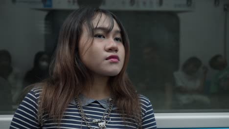 indonesian girl makes eye contact with camera on a subway ride