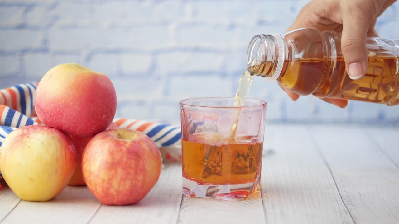 Versamento di succo di mela in un bicchiere