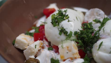 close up of a bowl of eggs, tomatoes, cheese and parsley