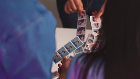 cerca de un grupo de amigos divirtiéndose mirando las impresiones de la cabina de fotos con accesorios 15