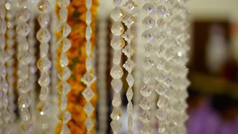 crystal clear acrylic bead hanging wedding supplies line chain around marry gold flowers, close up