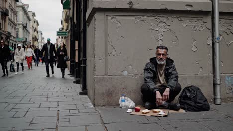 homeless man sitting on the sidewalk