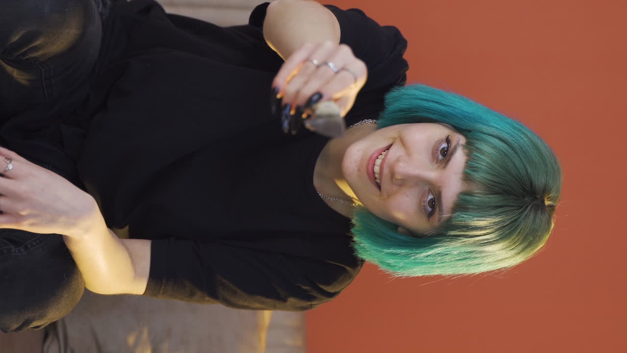 카메라에 칼을 겨누고 있는 정신나간 젊은 여성의 수직 비디오.