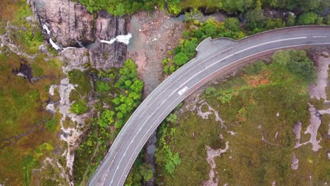 Car-Driving-A82-at-Glencoe-Waterfall,-The-Meeting-of-Three-Waters,-Scottish-Highlands,-Scotland---Aerial-Drone-4K-HD-Footage,-Top-Down