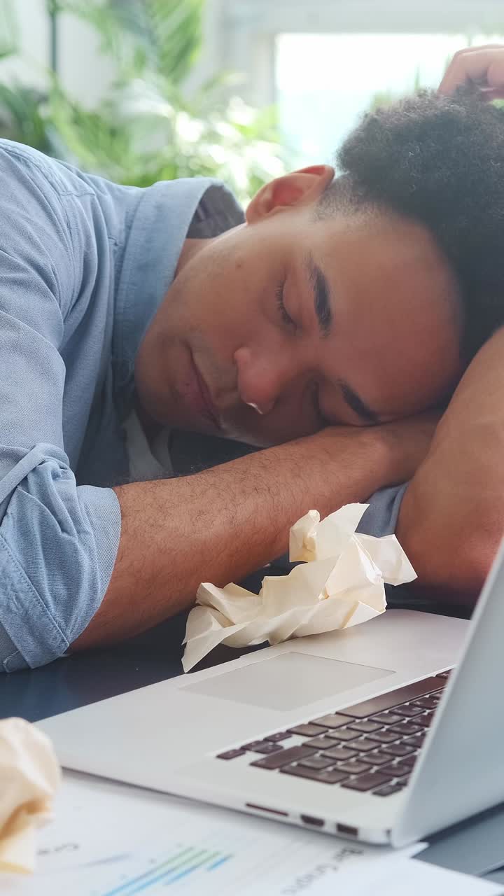 Struggling to focus a young professional battles fatigue in a sunny workspace