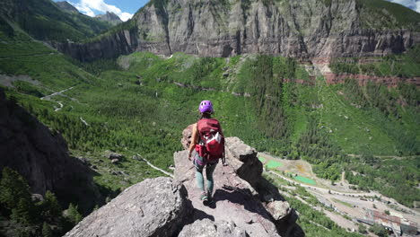 Vista-Posterior-De-La-Mujer-En-La-Cima-Del-Acantilado-Sobre-El-Abismo-Y-El-Impresionante-Paisaje-Del-Valle-Cerca-De-Telluride,-Colorado,-EE.UU.