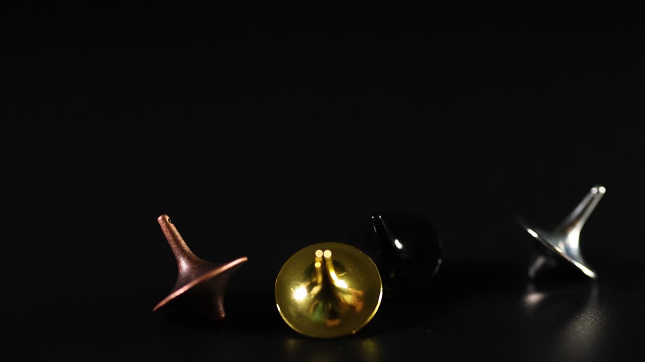 manos girando varias cimas de colores en una superficie