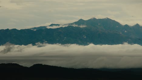 low lying fog over african landscape with mountain range in background