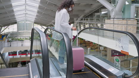 woman traveling on airport escalator