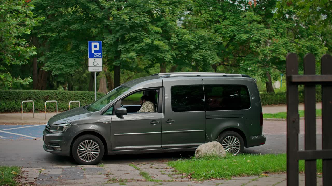 En grå varevogn parkeret på en handicapparkeringsplads