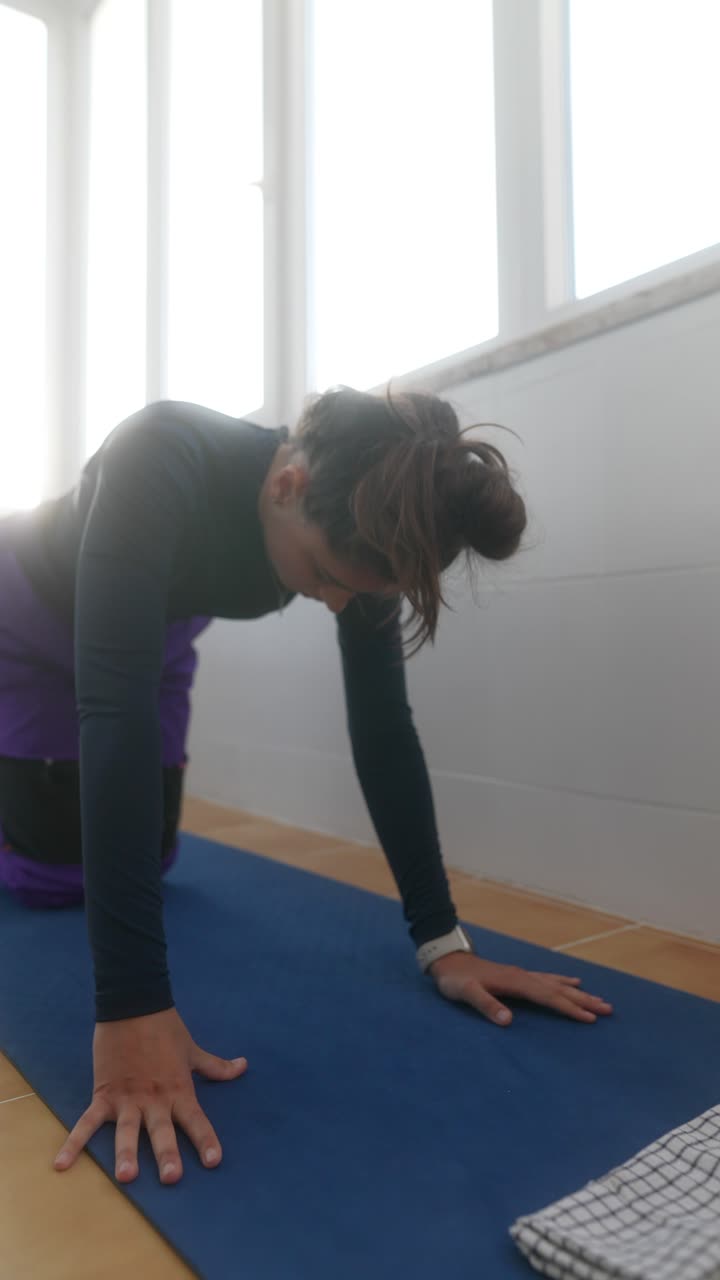 mujer haciendo ejercicios de yoga en casa
