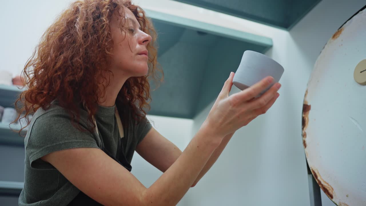 Woman Examining a Handmade Ceramic Cup