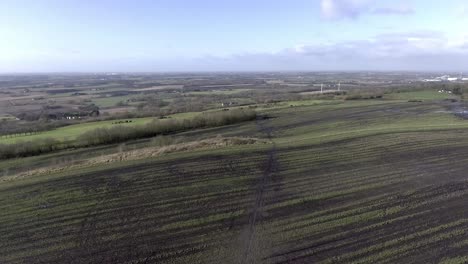 Idyllic-British-farming-meadows-countryside-fields-aerial-view-push-in-above-cultivated-landscape