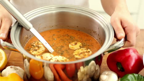 woman stirring soup in a saucepan