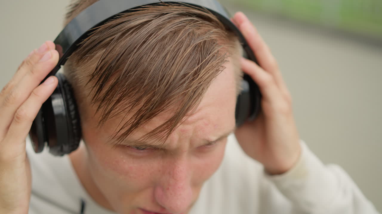 이어폰을 낀 젊은 백인 남성이 도시에서 운동하는 장면에서 비에 흠뻑 젖은 채로 전력 질주하고 있어요. 러너 타임, 트레이너 모드, 거리의 통근자, 비트에 집중, 이슬비에 흠뻑 젖은 채 운동 리허설을 하는 모습입니다.