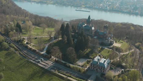 drone - toma aérea del castillo drachenburg y el río rin con un barco siebengebirge cerca de bonn - königswinter 30p