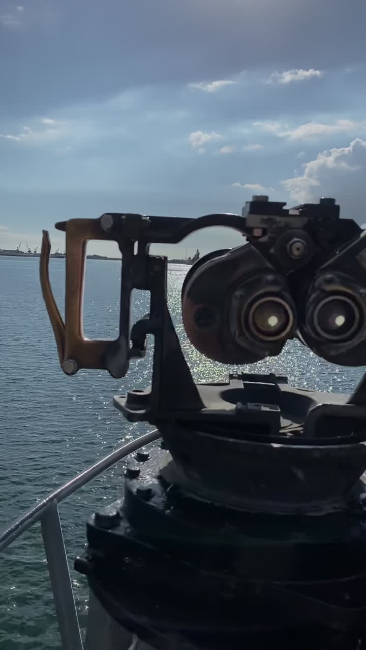 Una barca sul mare vista da un binocolo a gettoni. Verticale