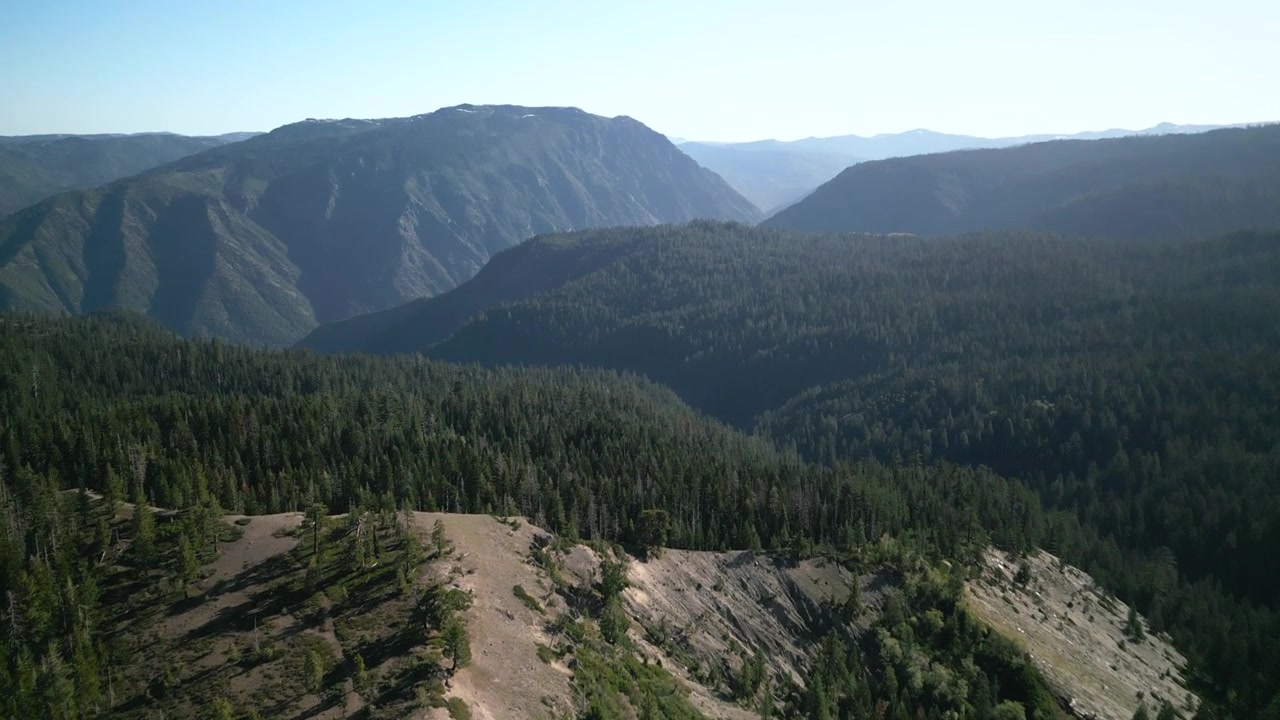 Aerial drone footage flying over a road in Lake Tahoe, California. Bird's eye view of a road and mountains. Perfect for nature documentaries and California travel content