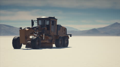 road grading machine on the salt desert road