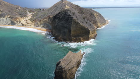 aerial view of a caribbean coast with stunning color and a big rock during a clear beautiful day