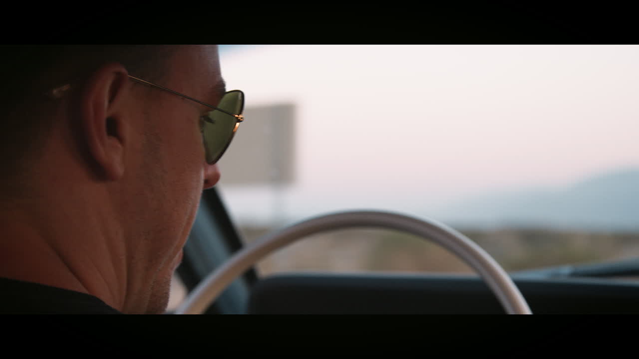 클래식 자동차를 운전하는 젊은 남자, 어깨를 넘어서서, 가까이서