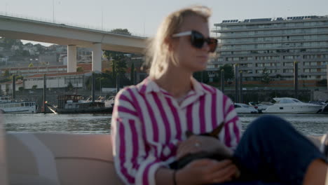 woman holding a dog on a river boat