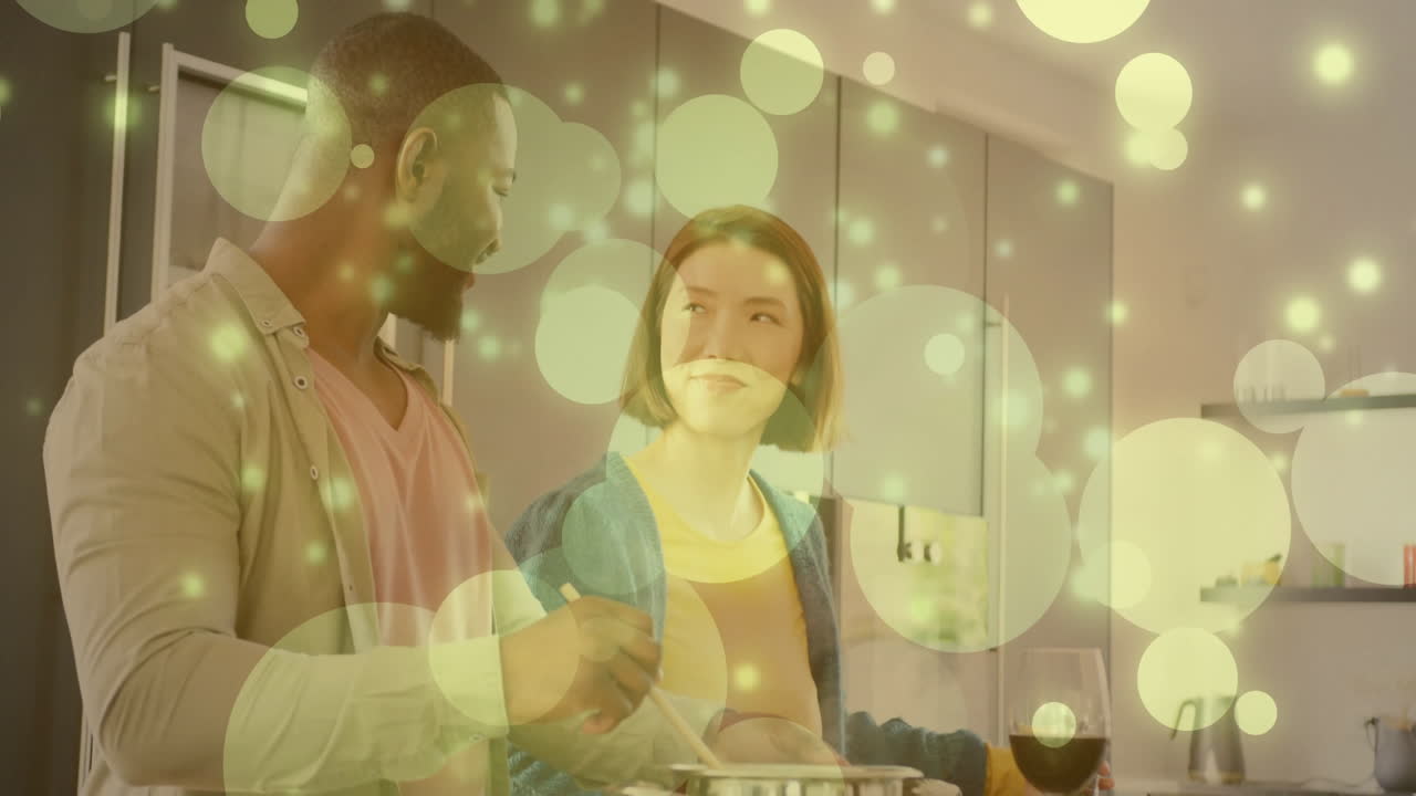 pareja sonriente cocinando juntos en la cocina con burbujas brillantes animación sobre la escena