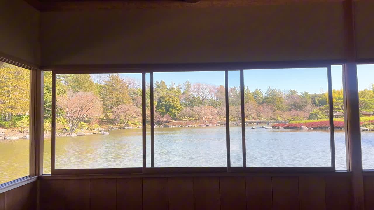 桜が咲く木造の東屋から眺める穏やかな日本庭園の風景。