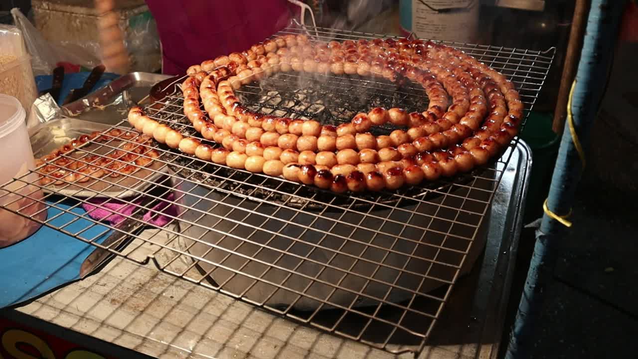 Popular Saturday Night Market Street Food in Chiang Mai, Thailand. Thai Street Food meat sausage balls grilled on a BBQ. A lively and fun night market