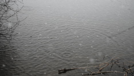 huge snow flakes create splashes in water as they fall in slow motion