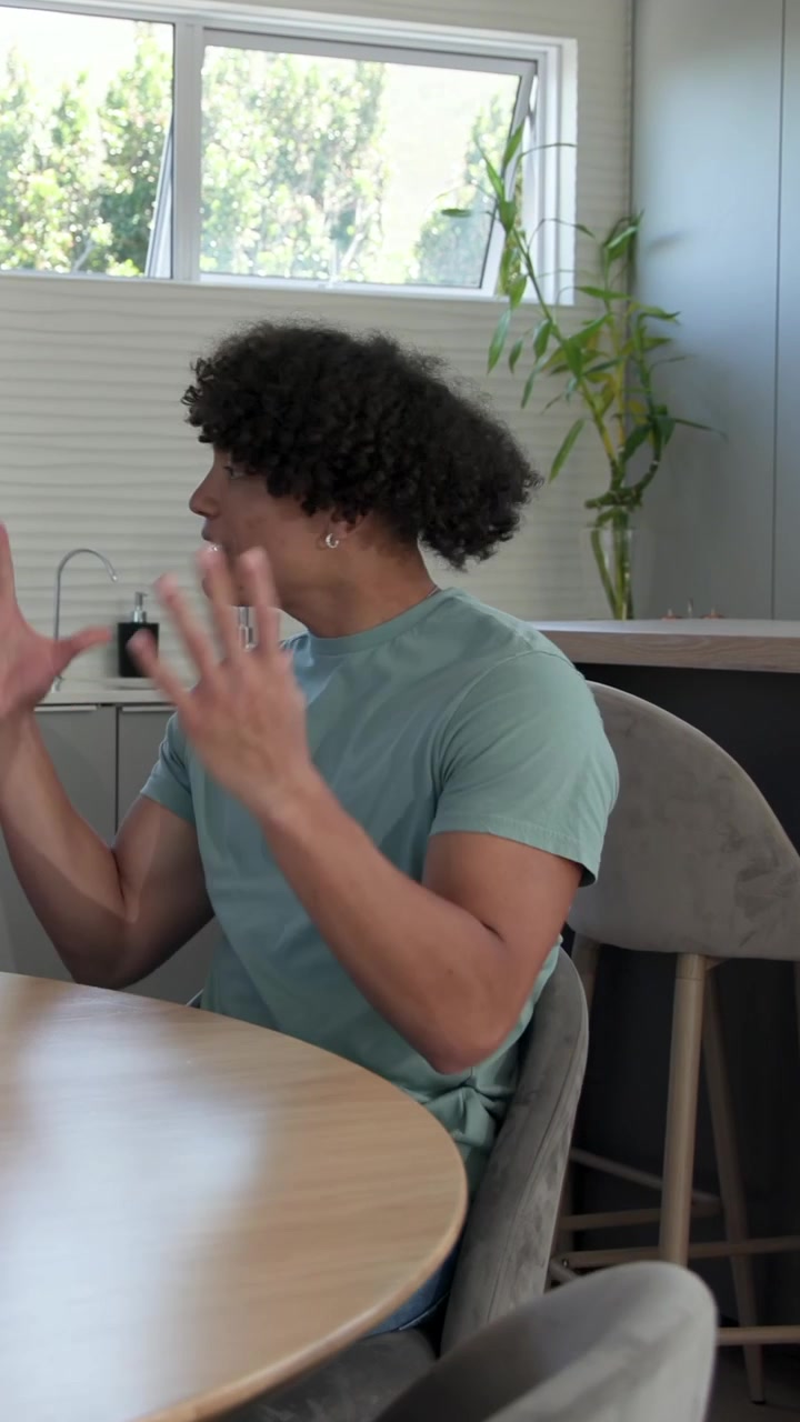 Man sitting at table, gesturing and tapping glass while pitching marketing, partner hand entering
