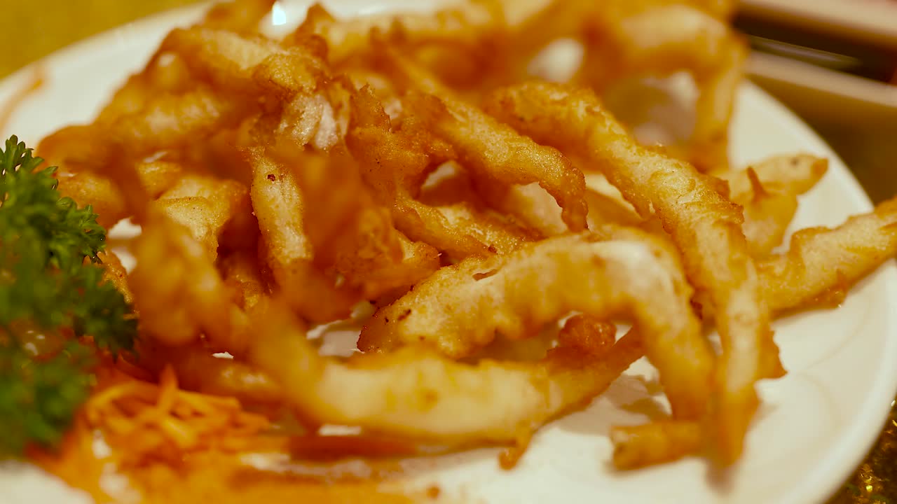 Golden fried snacks on a plate with garnish, captured in warm lighting at a Chinese restaurant in Gold Coast
