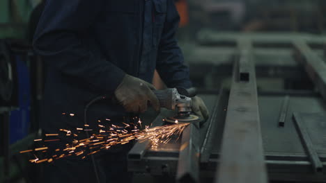 close-up: a man in goggles works with metal grinding polishing and stripping steel metal structures.