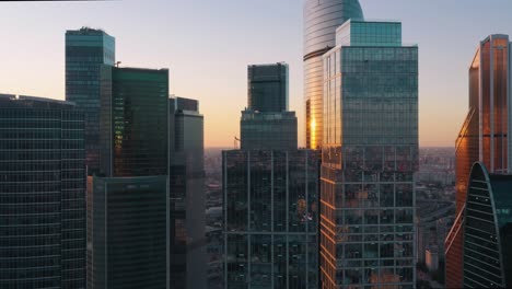 moscow city business centre glass buildings zoom in, cityscape horizon with setting sun