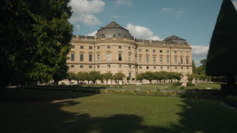 Establishing-view-of-Wurzburg-residence-between-shade-trees-behind-sculpture